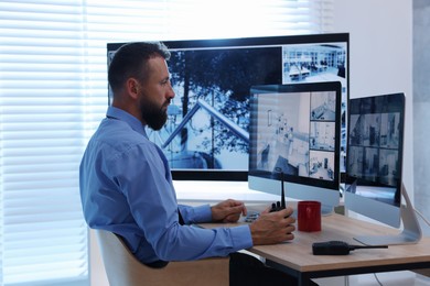 Photo of Security guard monitoring CCTV cameras in office