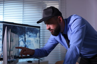 Photo of Security guard monitoring CCTV cameras in office