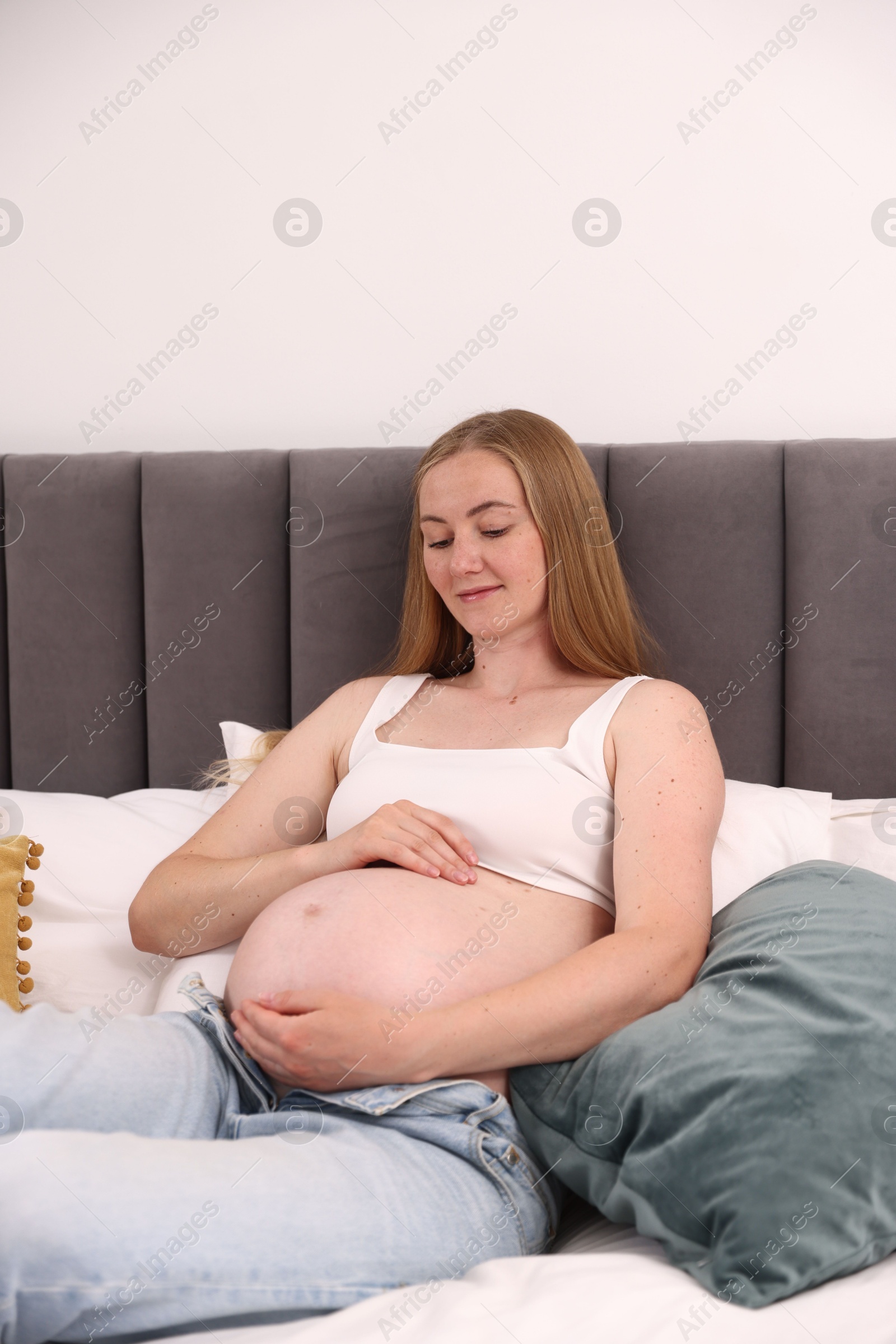 Beautiful pregnant woman on bed at home Photo of Beautiful pregnant woman on bed at home