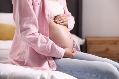Photo of Beautiful pregnant woman on bed at home, closeup