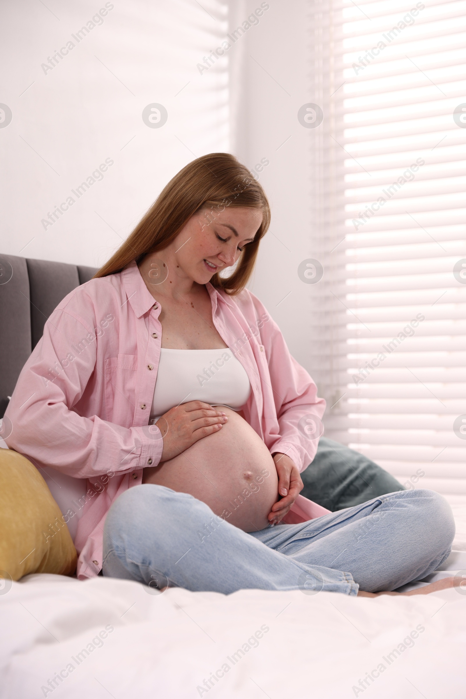 Beautiful pregnant woman on bed at home Photo of Beautiful pregnant woman on bed at home