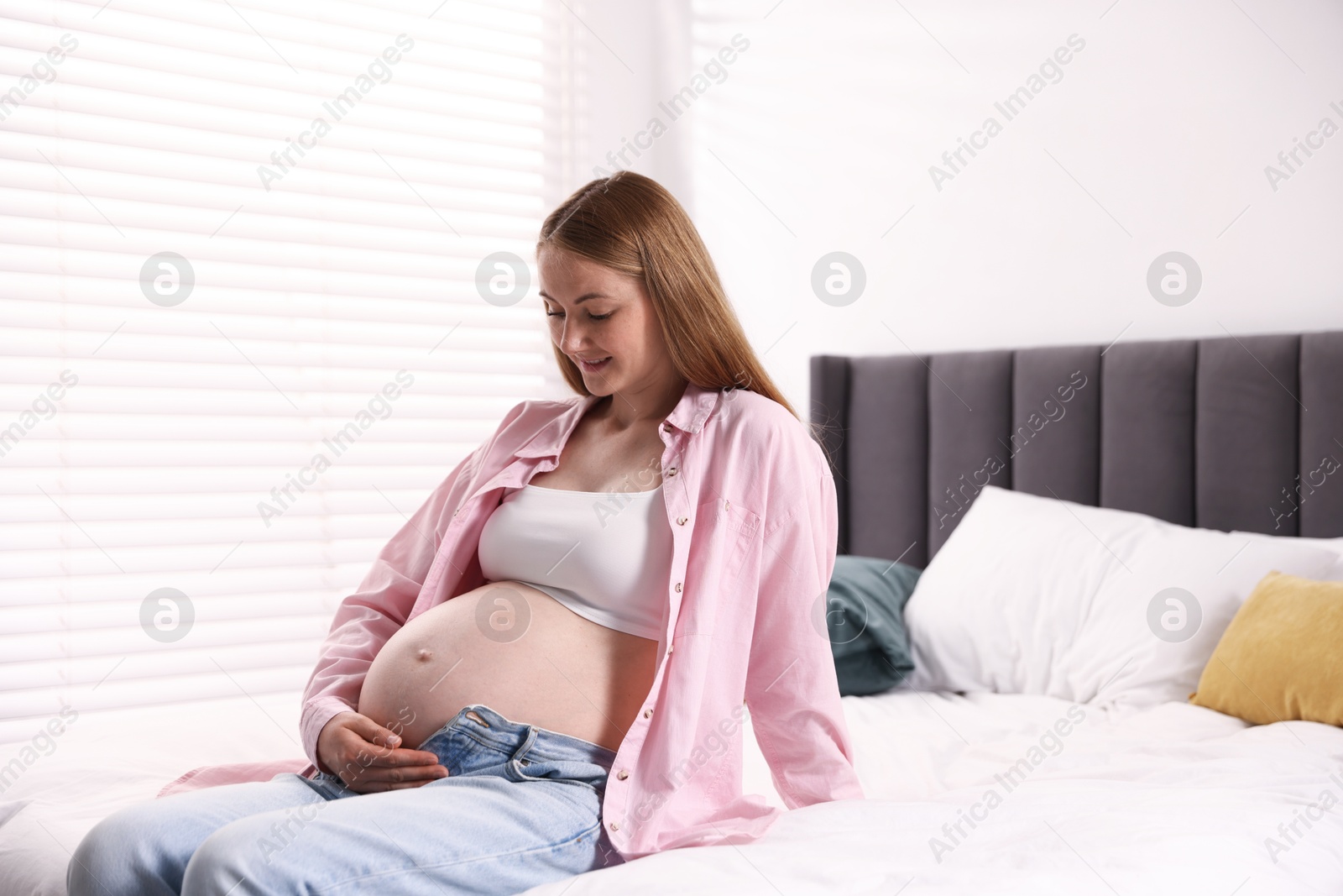 Beautiful pregnant woman on bed at home Photo of Beautiful pregnant woman on bed at home