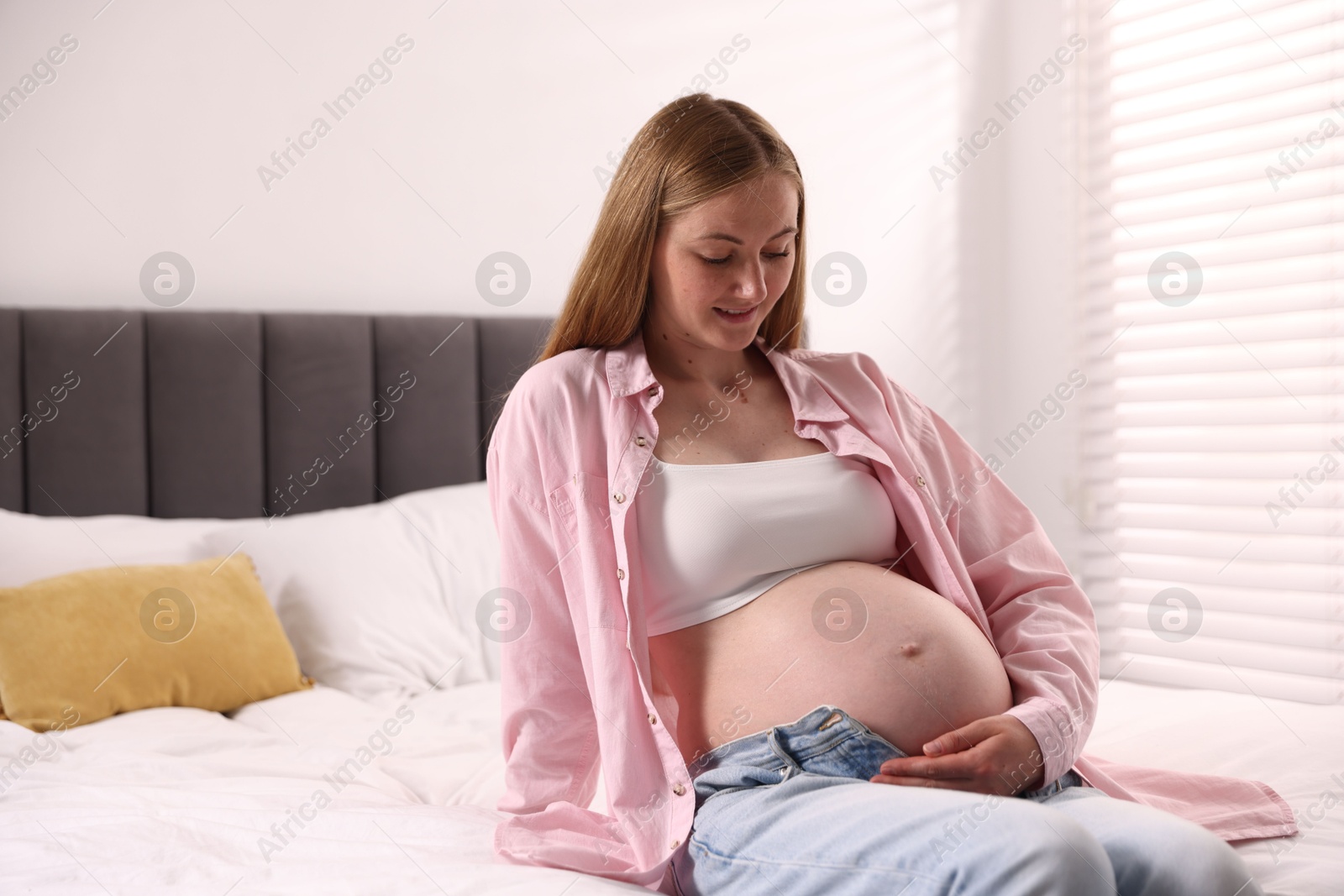 Beautiful pregnant woman on bed at home Photo of Beautiful pregnant woman on bed at home