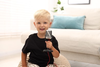 Photo of Cute little boy with microphone at home