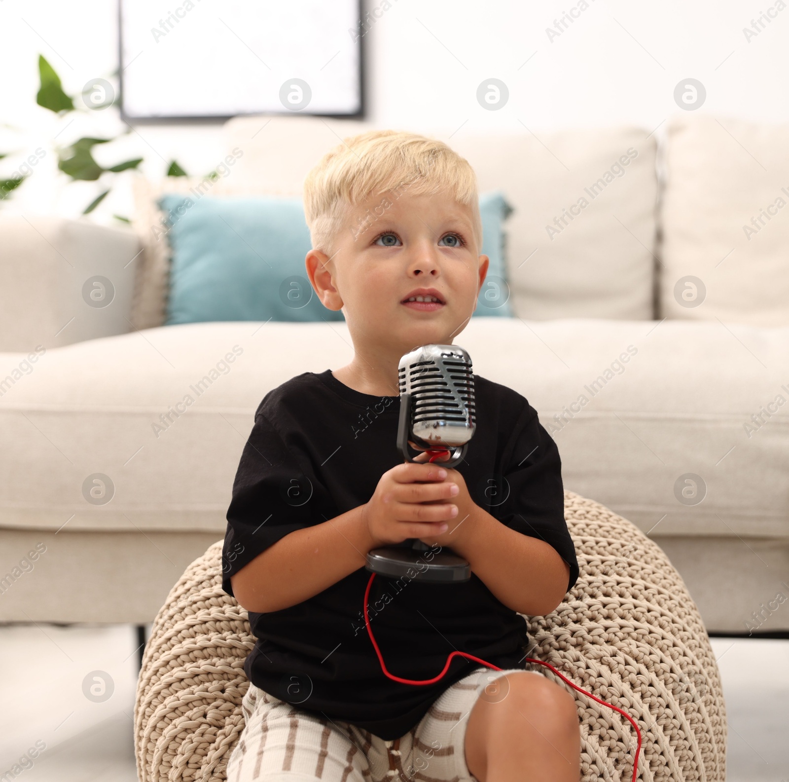 Photo of Cute little boy with microphone at home