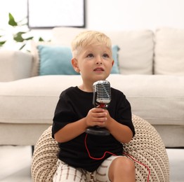 Photo of Cute little boy with microphone at home
