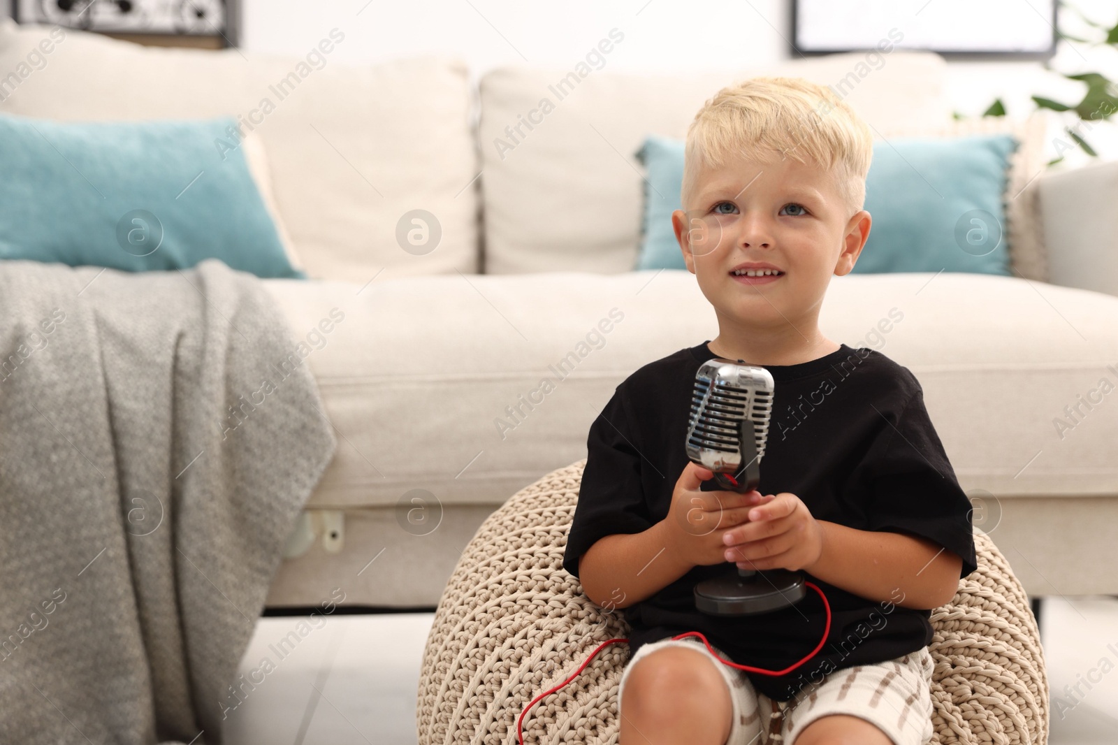 Photo of Cute little boy with microphone at home
