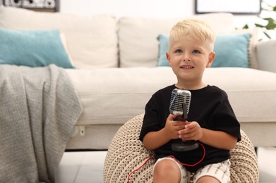 Photo of Cute little boy with microphone at home