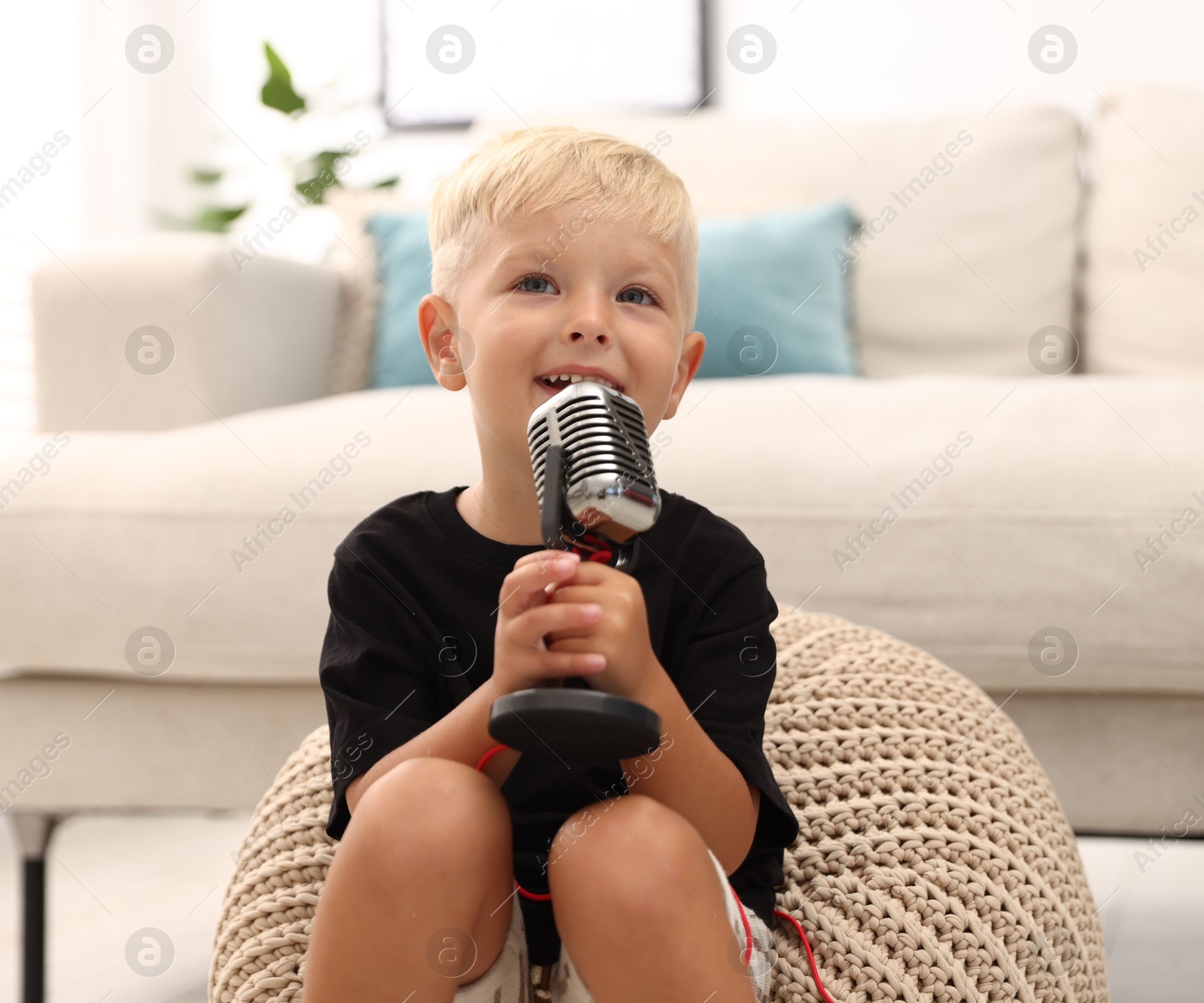 Photo of Cute little boy with microphone at home