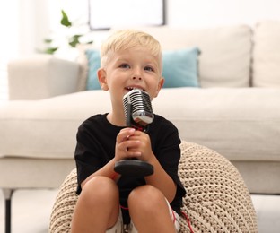 Photo of Cute little boy with microphone at home