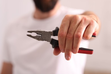 Photo of Closeup view of man with pliers indoors