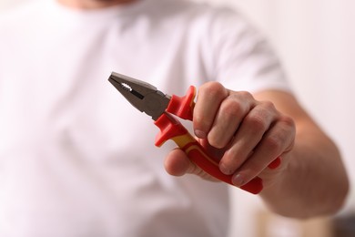Photo of Closeup view of man with pliers indoors