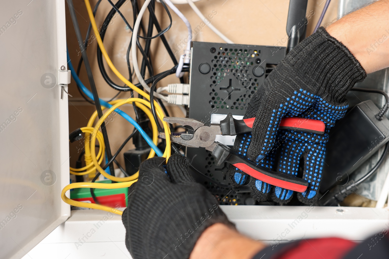 Man fixing heating radiator with pliers indoors, closeup Photo of Man fixing heating radiator with pliers indoors, closeup