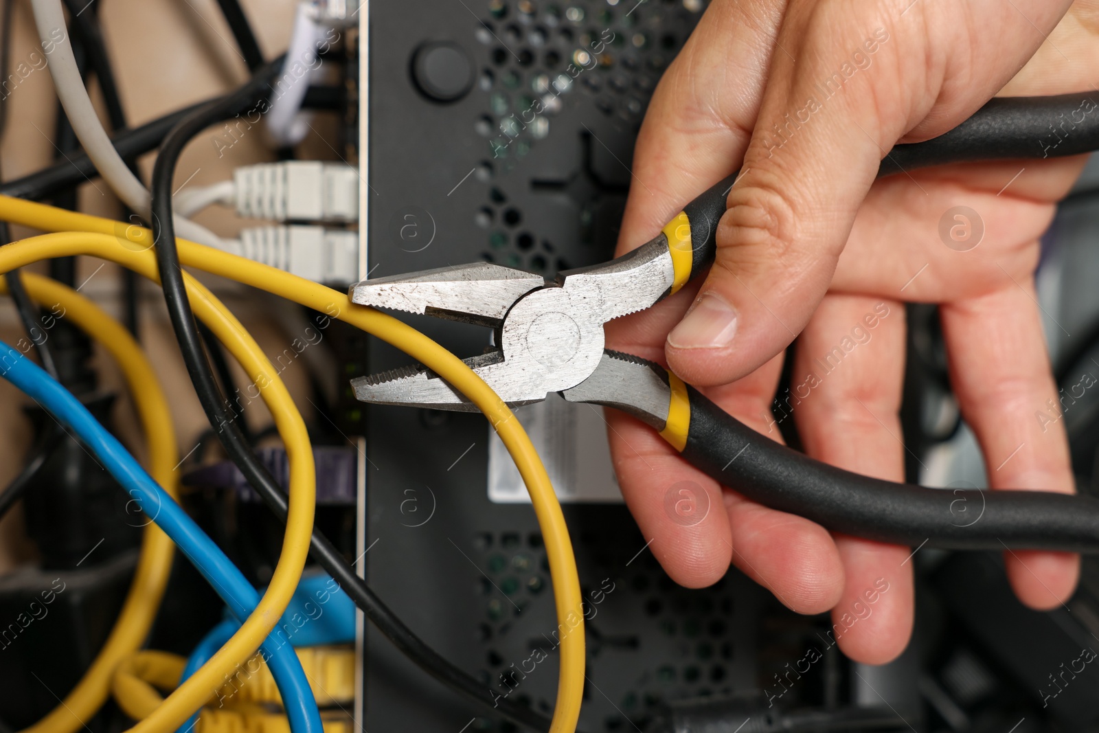 Man fixing heating radiator with pliers indoors, closeup Photo of Man fixing heating radiator with pliers indoors, closeup