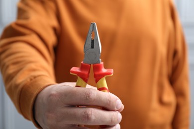 Photo of Closeup view of man with pliers indoors