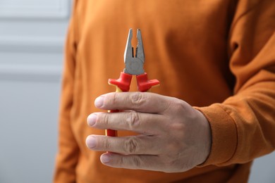 Photo of Closeup view of man with pliers indoors
