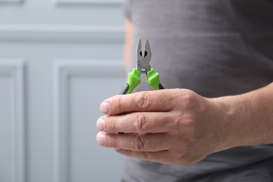 Photo of Man with pliers indoors, space for text