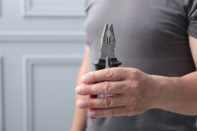 Photo of Man with pliers indoors, space for text