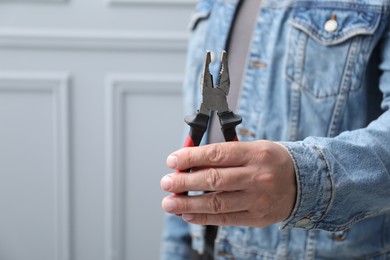 Photo of Man with pliers indoors, space for text