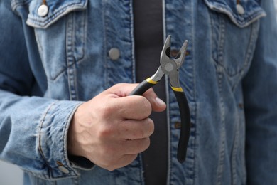 Photo of Closeup view of man with pliers indoors