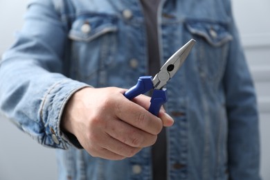 Photo of Closeup view of man with pliers indoors