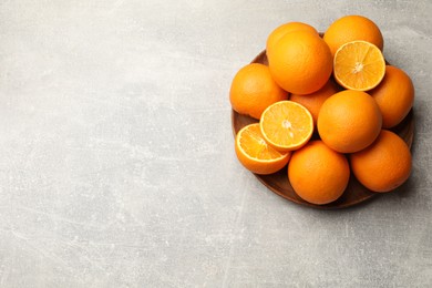 Photo of Fresh ripe oranges on grey table, top view. Space for text