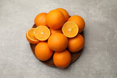 Photo of Fresh ripe oranges on grey table, top view