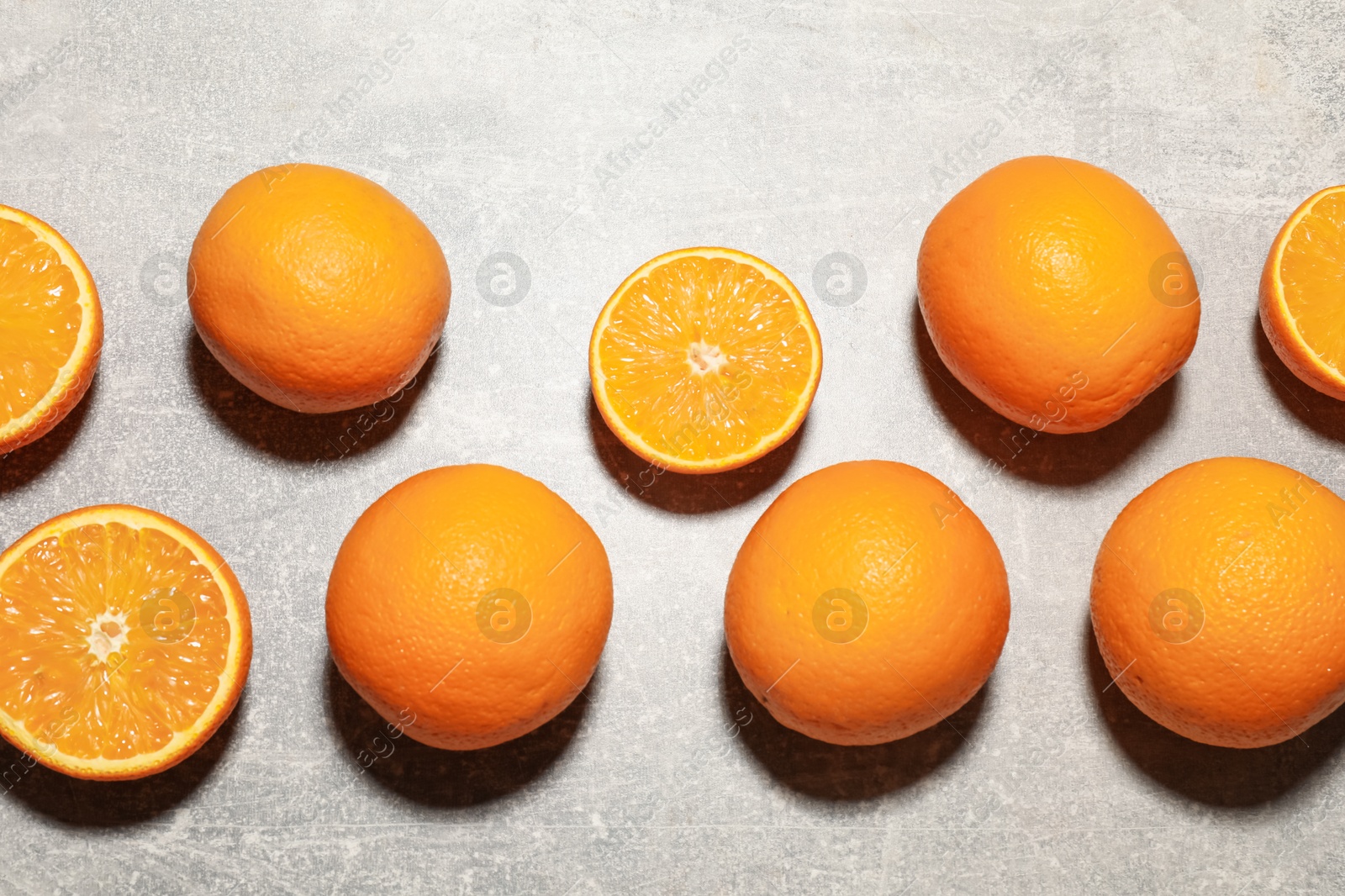 Fresh ripe oranges on grey table, flat lay Photo of Fresh ripe oranges on grey table, flat lay