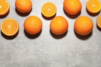 Photo of Fresh ripe oranges on grey table, flat lay. Space for text
