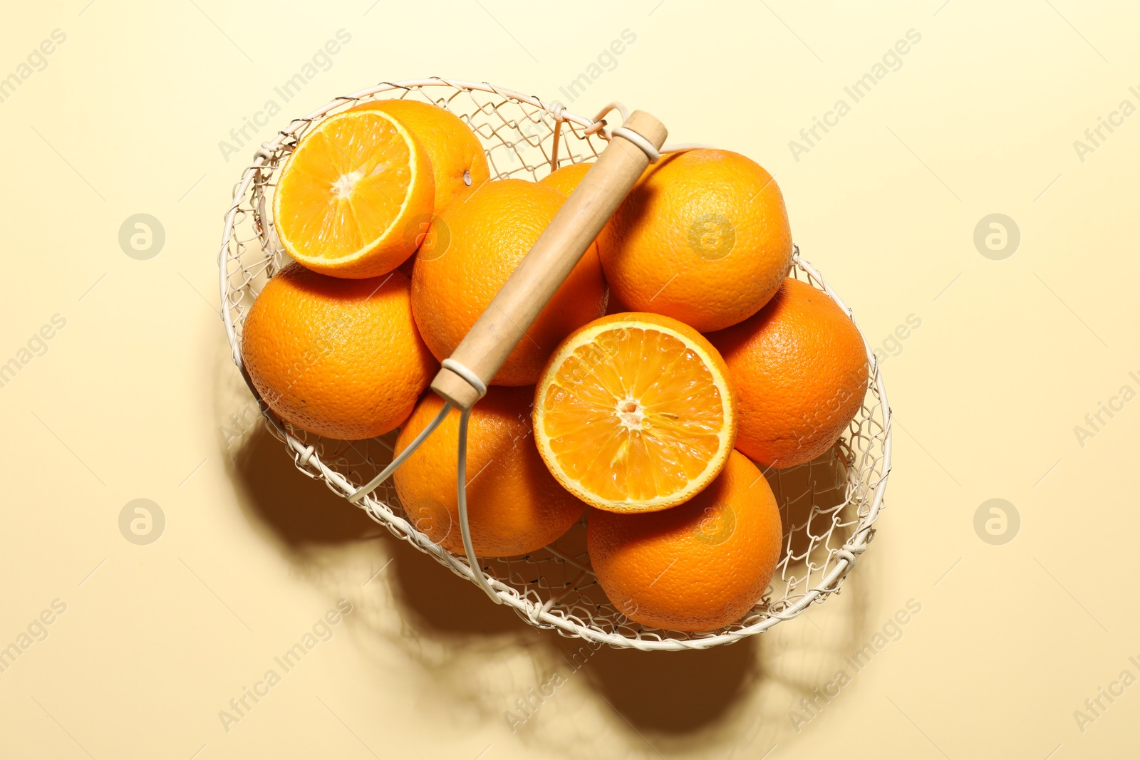 Fresh ripe oranges in basket on beige background, top view Photo of Fresh ripe oranges in basket on beige background, top view