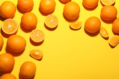 Photo of Fresh ripe oranges on yellow background, flat lay. Space for text