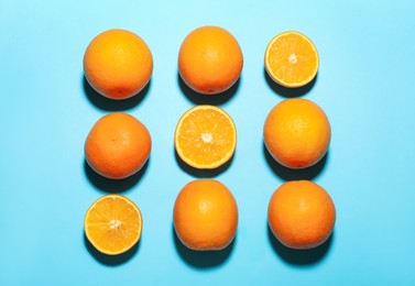 Photo of Fresh ripe oranges on light blue background, flat lay