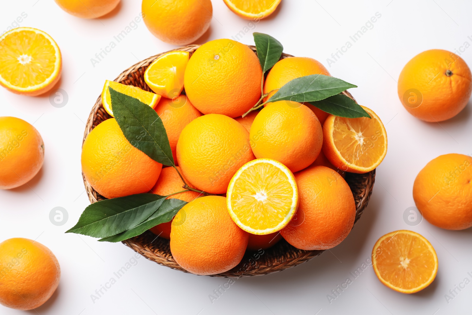 Fresh ripe oranges and green leaves on white background, flat lay Photo of Fresh ripe oranges and green leaves on white background, flat lay