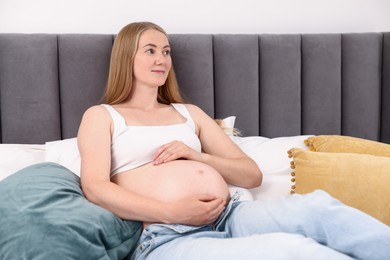 Photo of Beautiful pregnant woman on bed at home