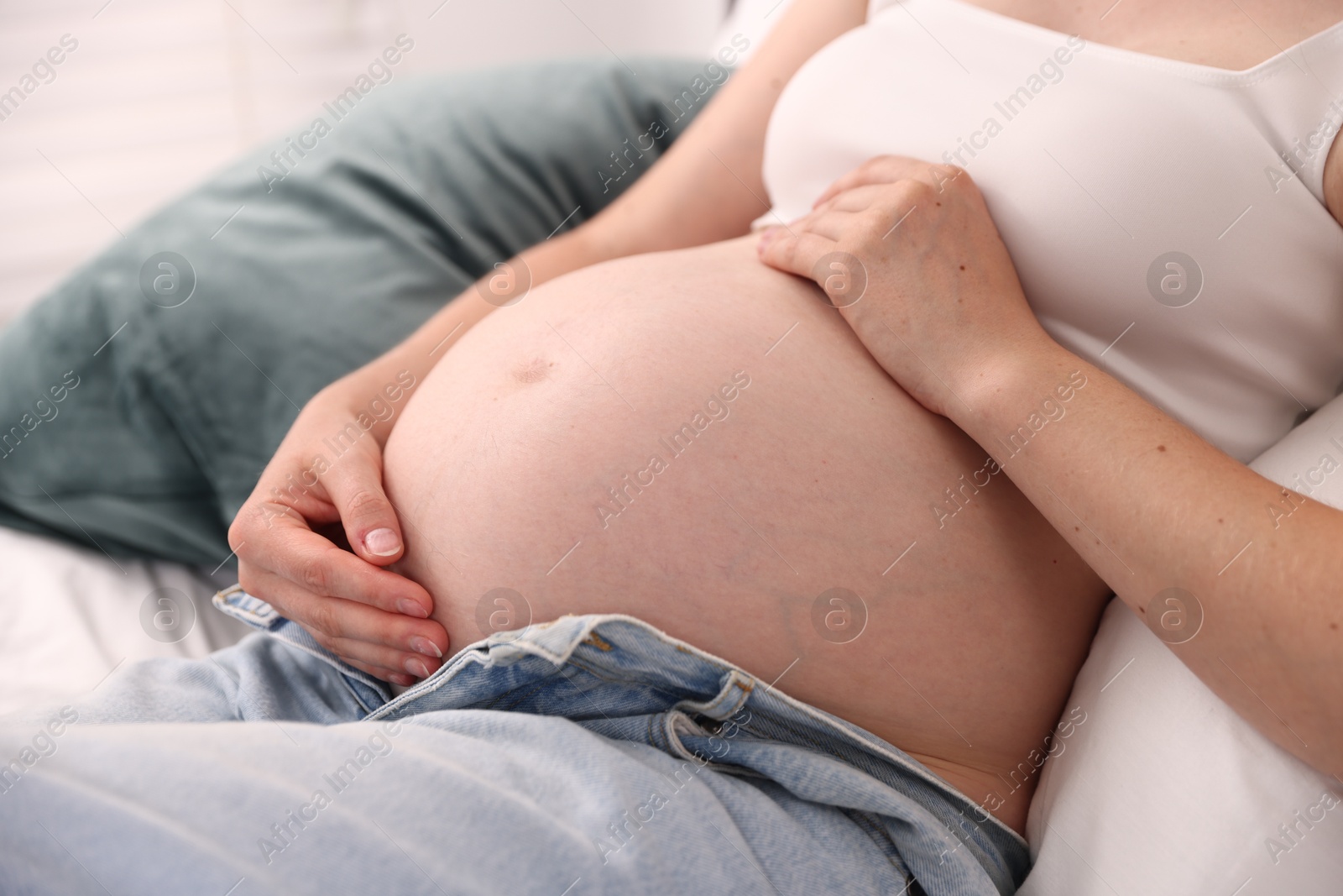 Beautiful pregnant woman on bed at home, closeup Photo of Beautiful pregnant woman on bed at home, closeup