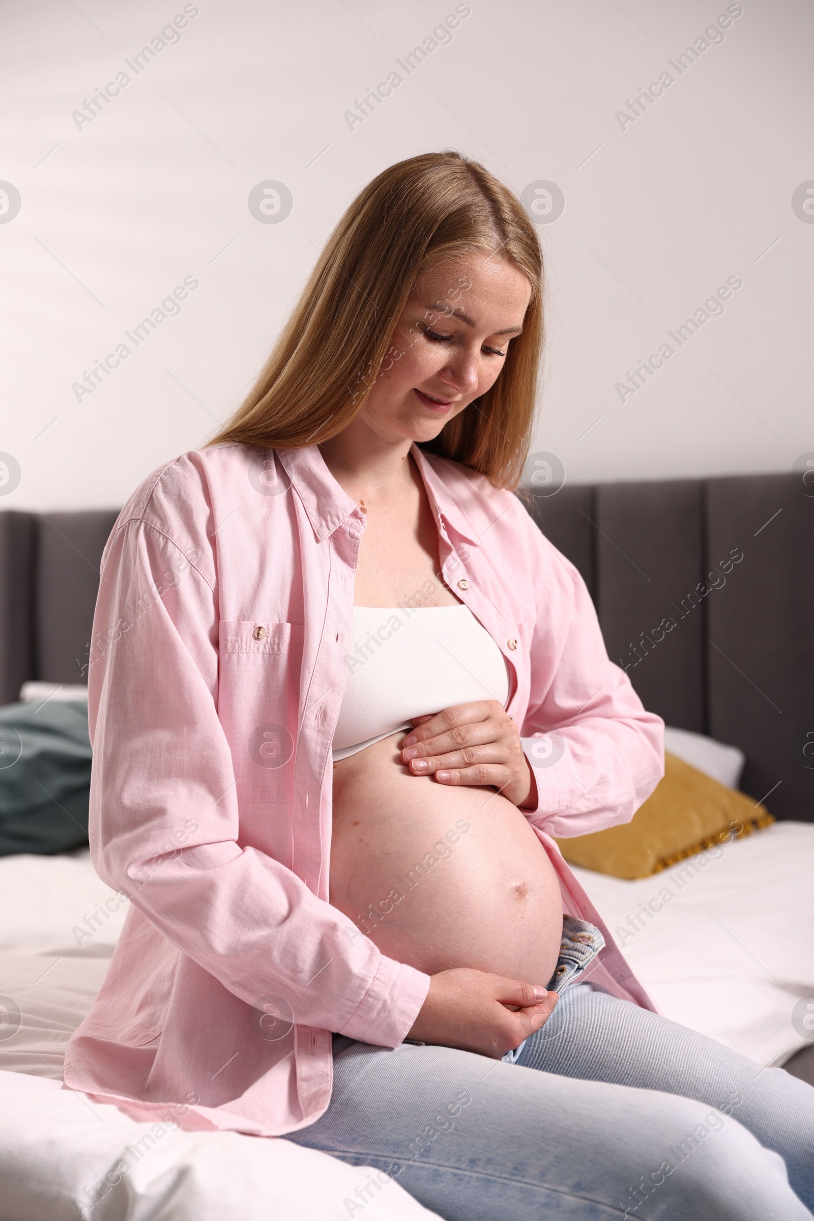 Beautiful pregnant woman on bed at home Photo of Beautiful pregnant woman on bed at home