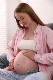 Photo of Beautiful pregnant woman on bed at home