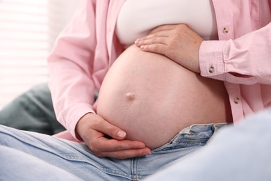 Photo of Beautiful pregnant woman on bed at home, closeup