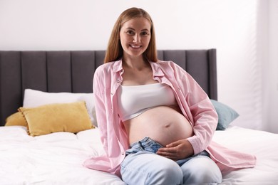 Photo of Beautiful pregnant woman on bed at home