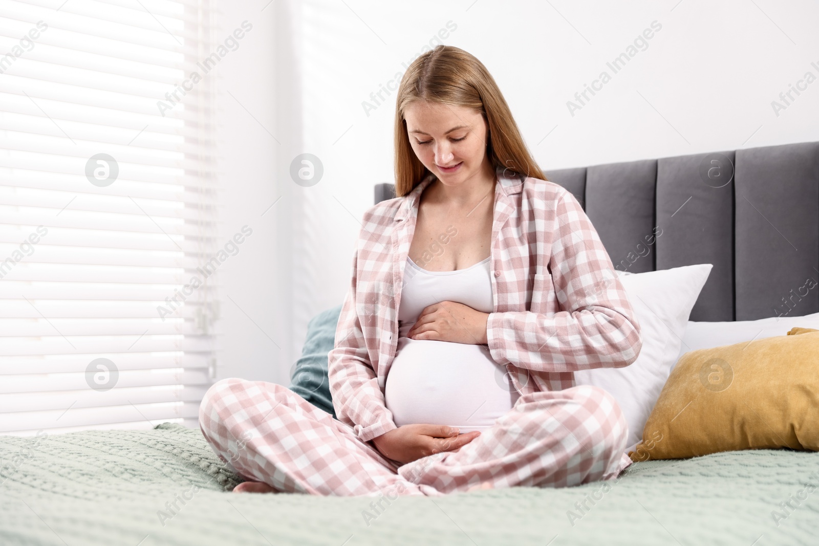 Beautiful pregnant woman on bed at home Photo of Beautiful pregnant woman on bed at home