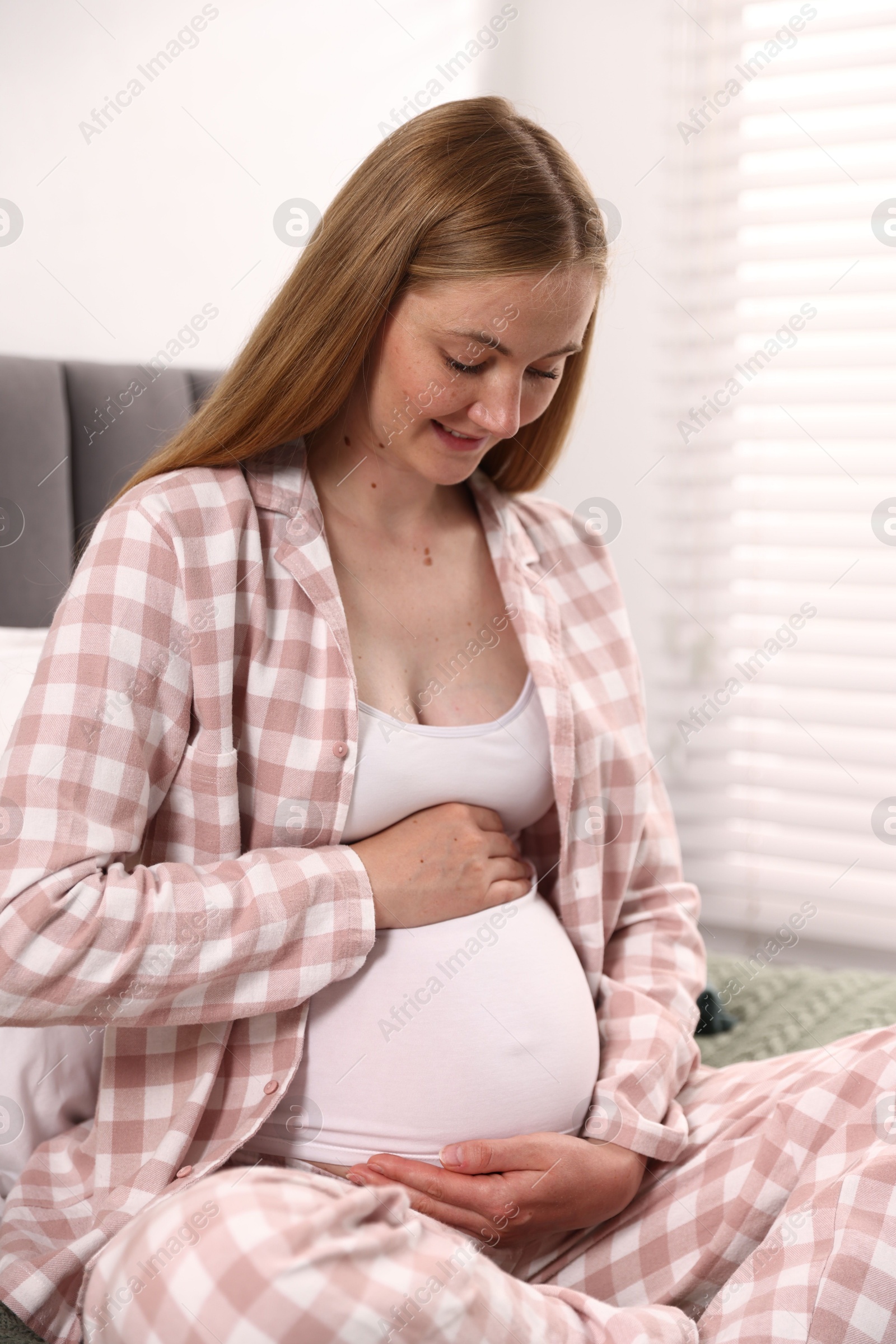 Beautiful pregnant woman on bed at home Photo of Beautiful pregnant woman on bed at home