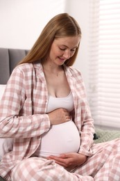Photo of Beautiful pregnant woman on bed at home