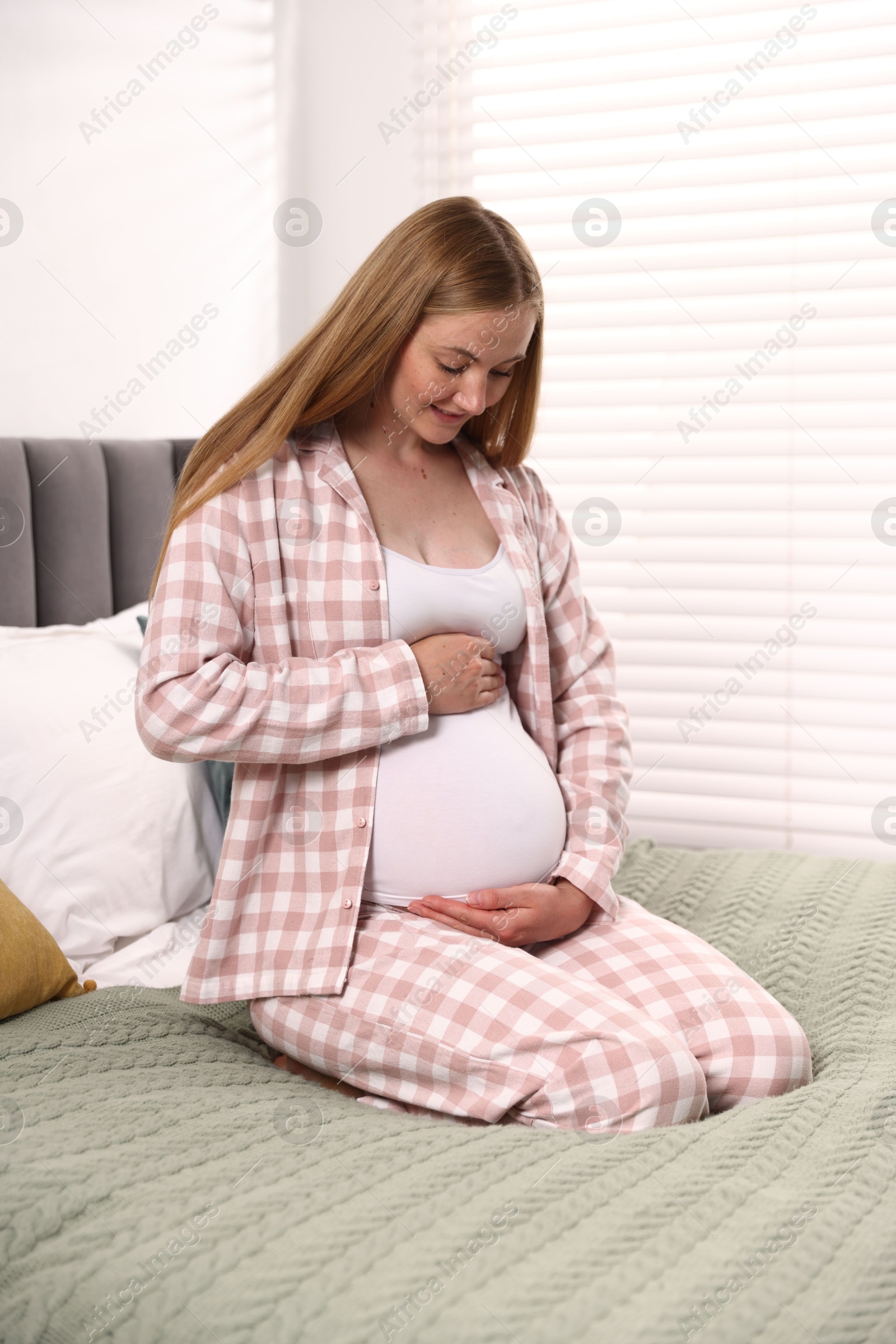 Beautiful pregnant woman on bed at home Photo of Beautiful pregnant woman on bed at home