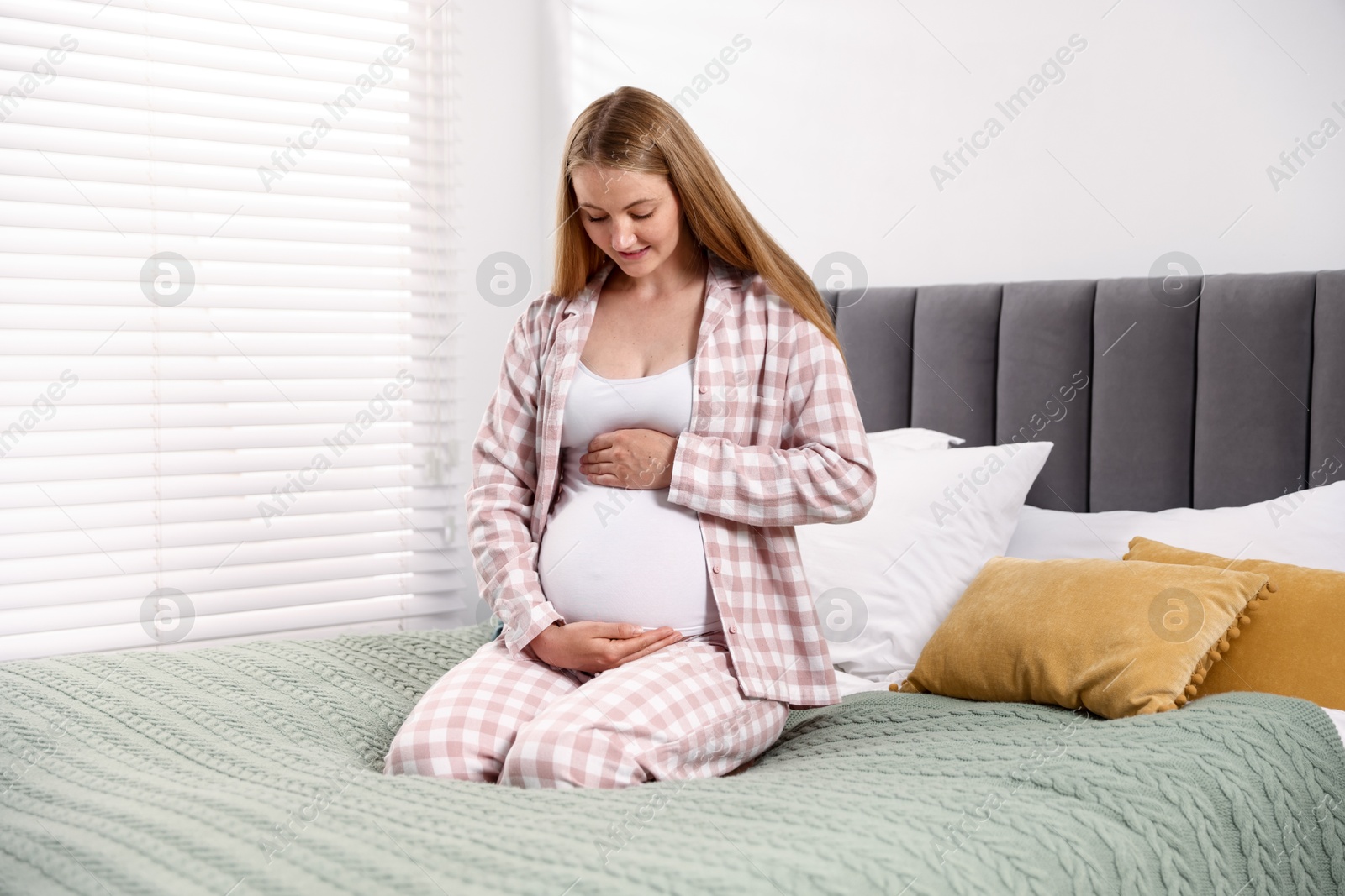 Beautiful pregnant woman on bed at home Photo of Beautiful pregnant woman on bed at home