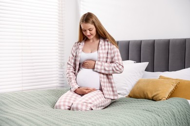 Photo of Beautiful pregnant woman on bed at home