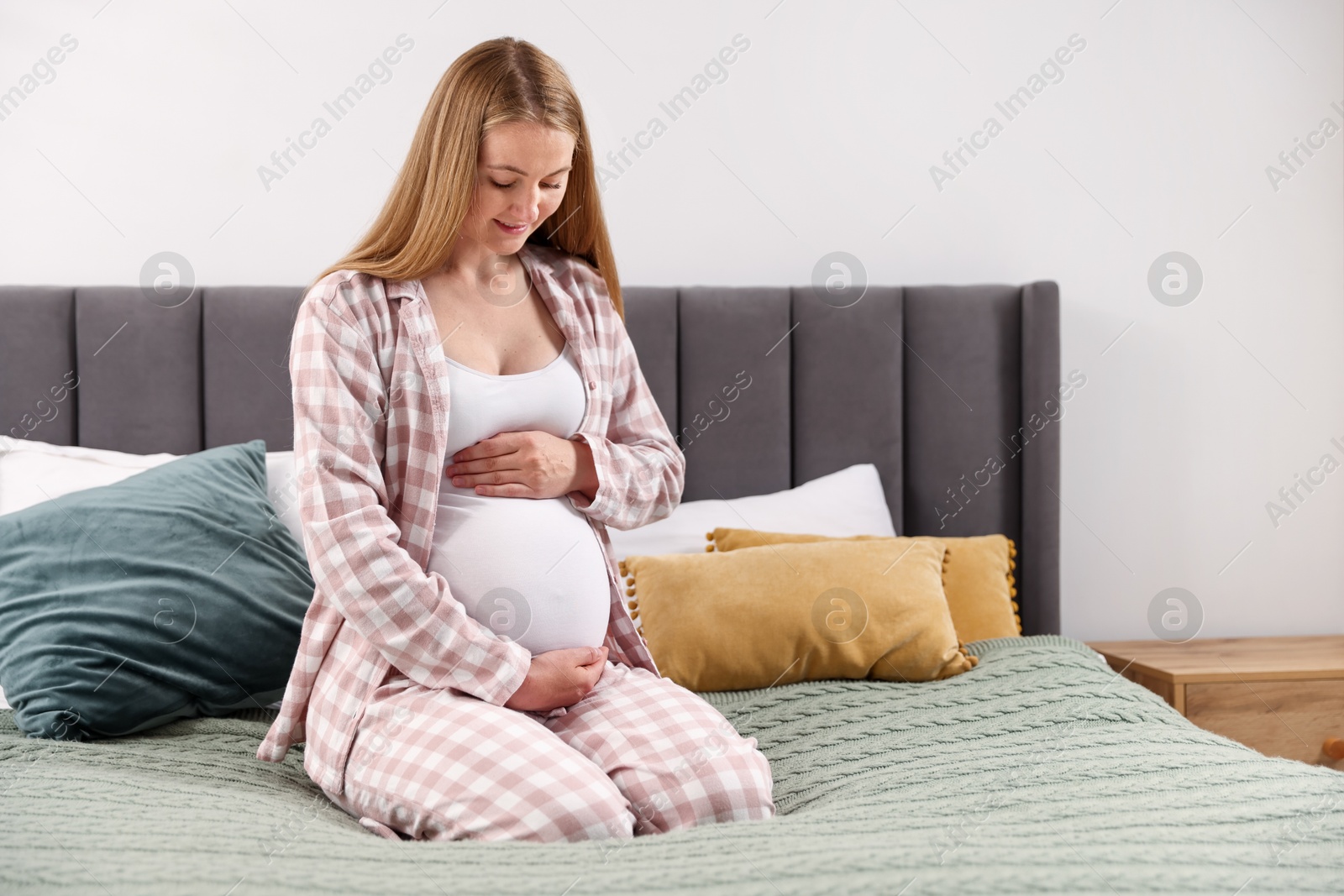 Beautiful pregnant woman on bed at home Photo of Beautiful pregnant woman on bed at home