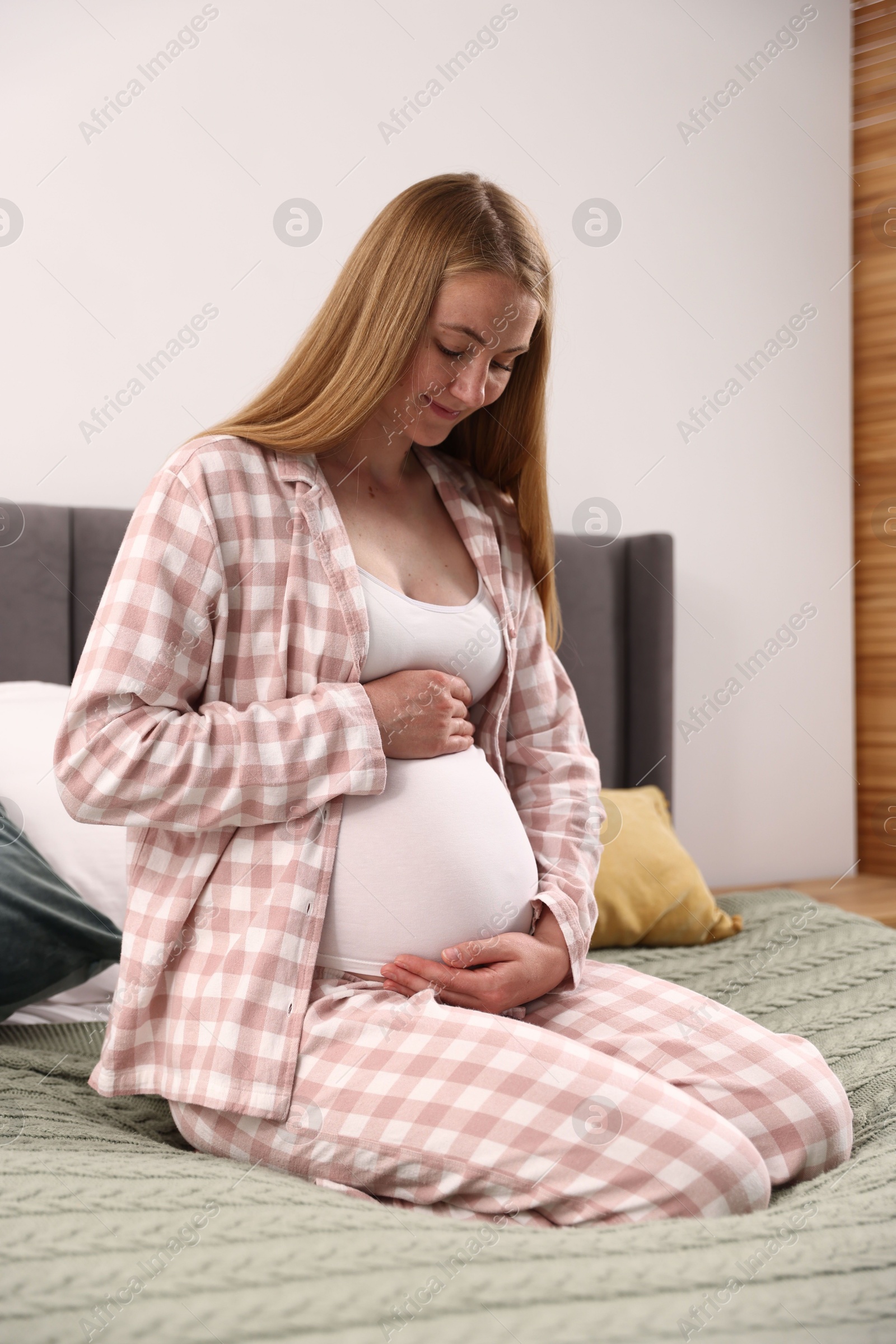 Beautiful pregnant woman on bed at home Photo of Beautiful pregnant woman on bed at home
