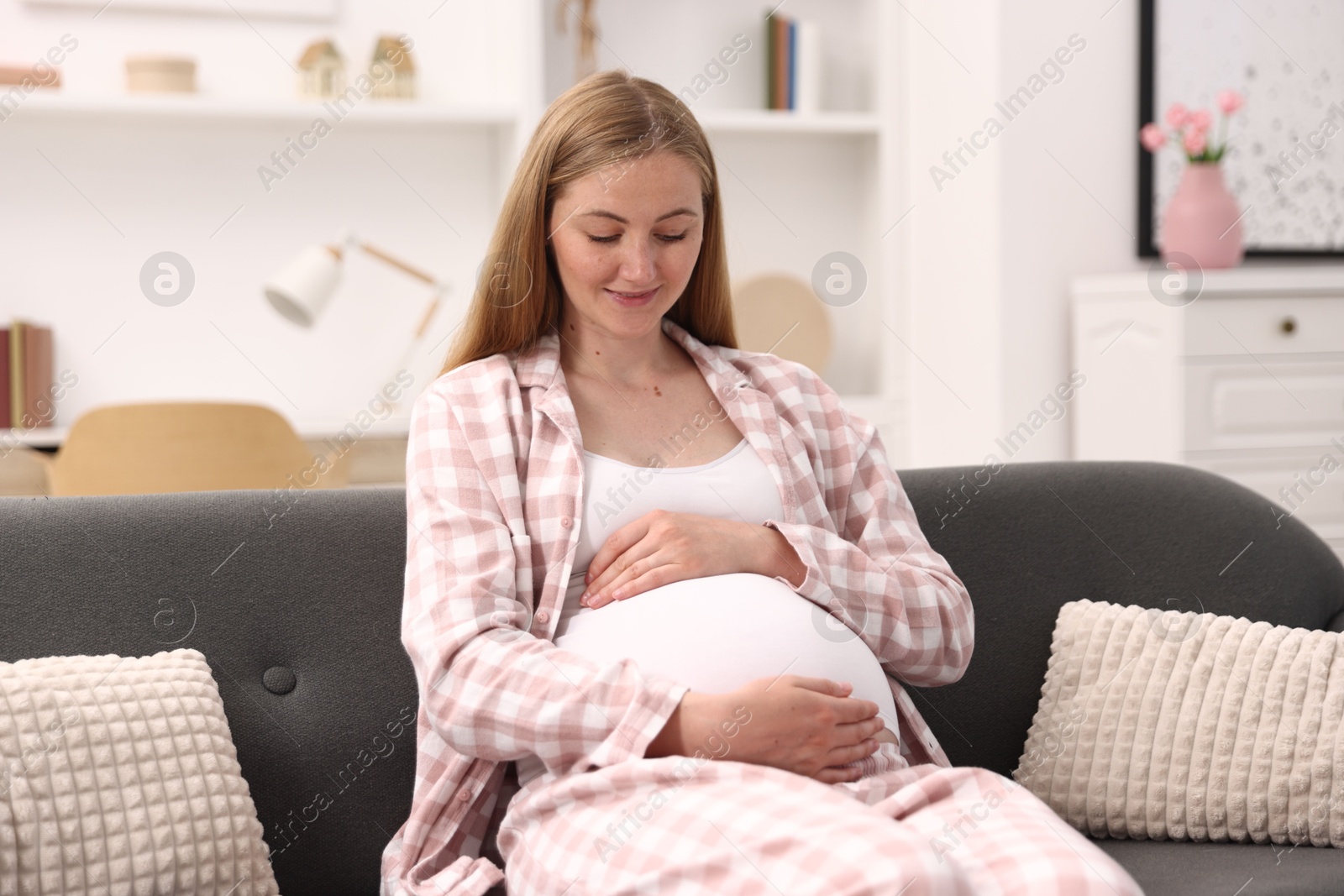 Beautiful pregnant woman on sofa at home Photo of Beautiful pregnant woman on sofa at home