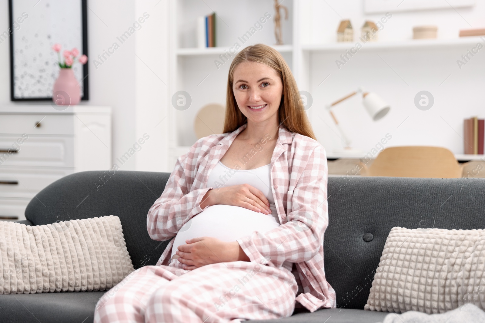 Photo of Beautiful pregnant woman on sofa at home
