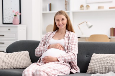Photo of Beautiful pregnant woman on sofa at home